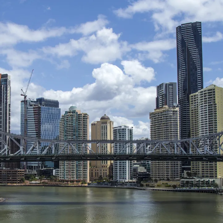 The finished puzzle: the Story Bridge's steel truss across the river in front of Brisbane's city towers and summer clouds